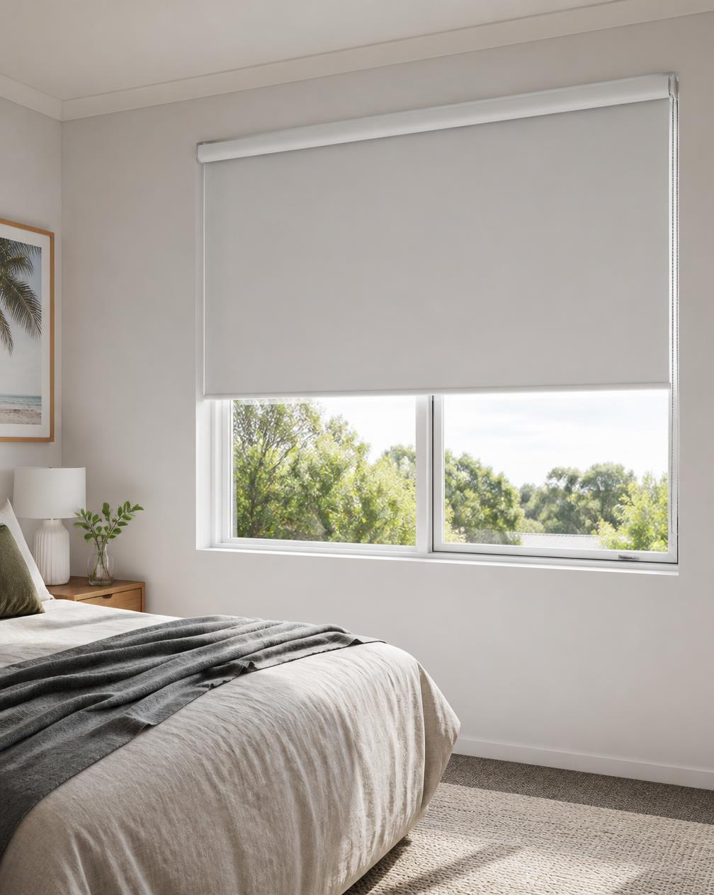 Bedroom with a block-out roller blind half drawn